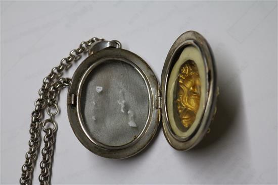 An Indian white and yellow metal oval locket embossed with a deity, on a white metal chain, locket 5cm.